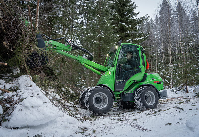 Ein grüner Avant Hoflader Serie 700 bei der Arbeit im Wald
