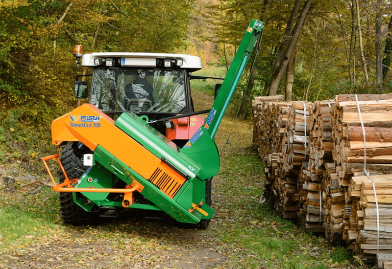 Ein POSCH Sägeautomat an einem Traktor bei der Holzverarbeitung in einem Wald