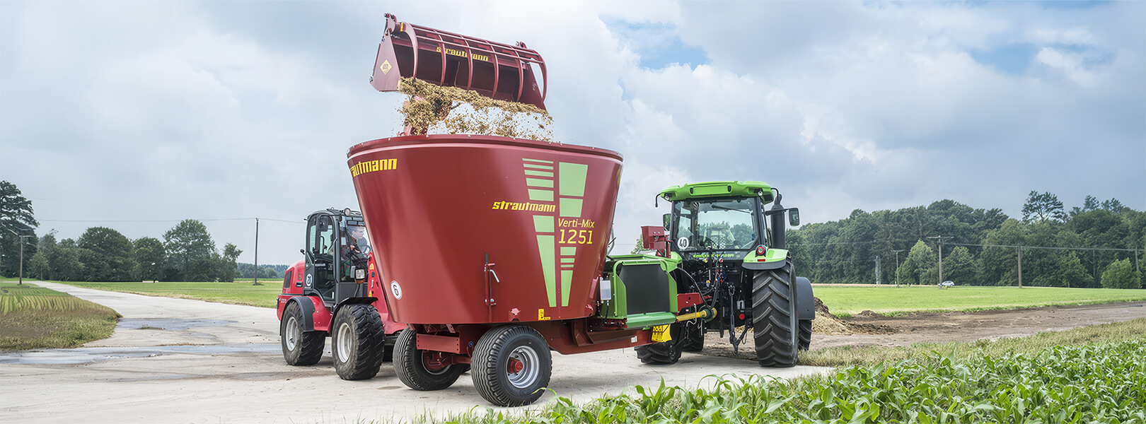 Strautmann Verti-Mix 1251 der von einem Hoflader mit Futter beladen wird