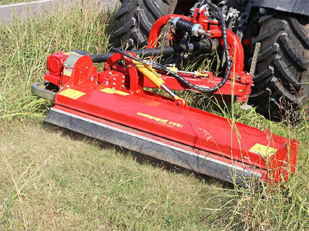SEPPI M. Mulchgerät an einem Traktor im Einsatz auf einer Grünfläche mit hohem Gras