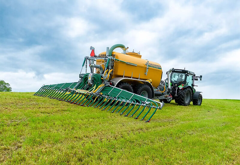 Traktor auf einem hügeligen Feld bei der Gülle ausbringung mir einem Zunhammer AlpenGlideFix