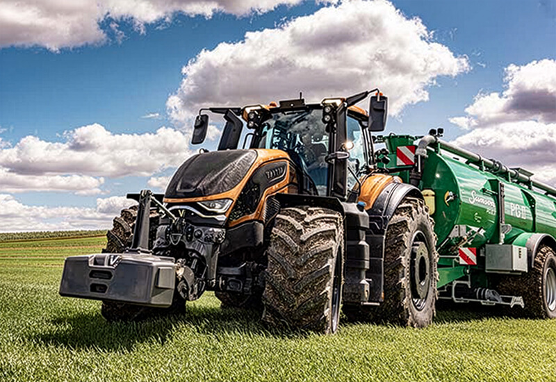 Valtra S-Serie mit Anhänger auf einer grünen Wiese im Einsatz